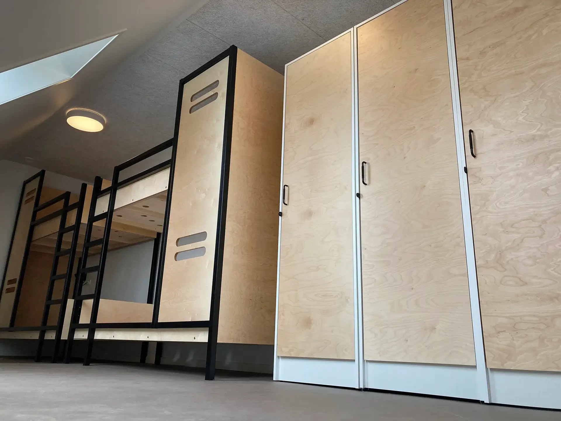 Custom-built bunk beds and integrated lockers for school dormitories, combining space-saving design and durable materials.